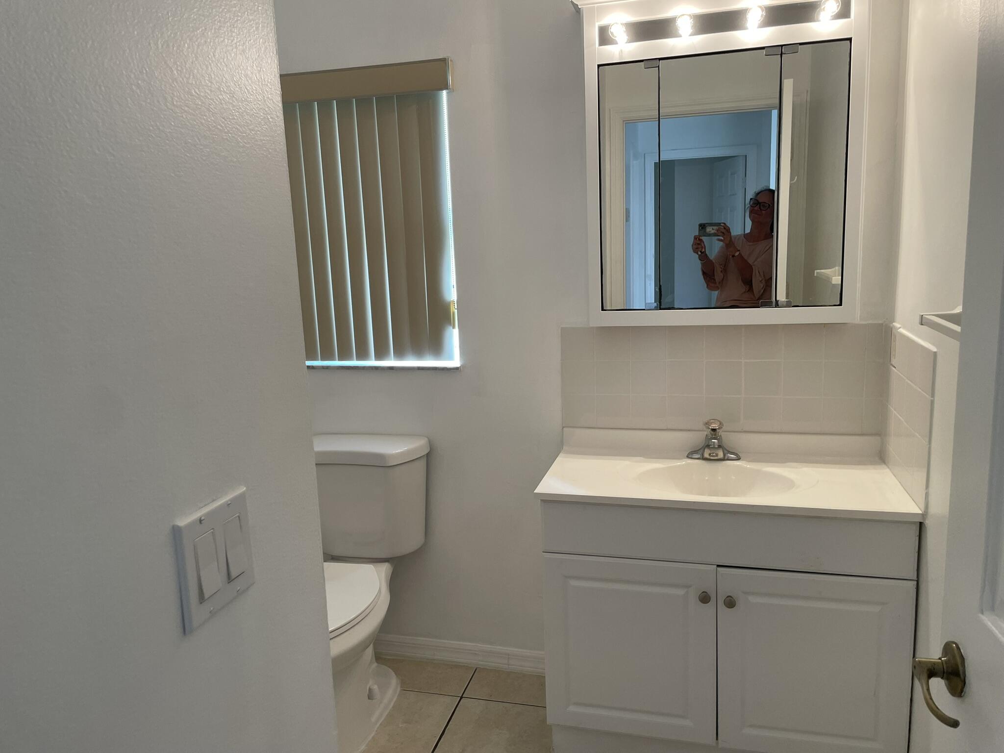 4448 Northwest Bighorn Avenue Port St. Lucie, FL 34983 - Photo 13 of 19 a bathroom with a toilet sink and mirror