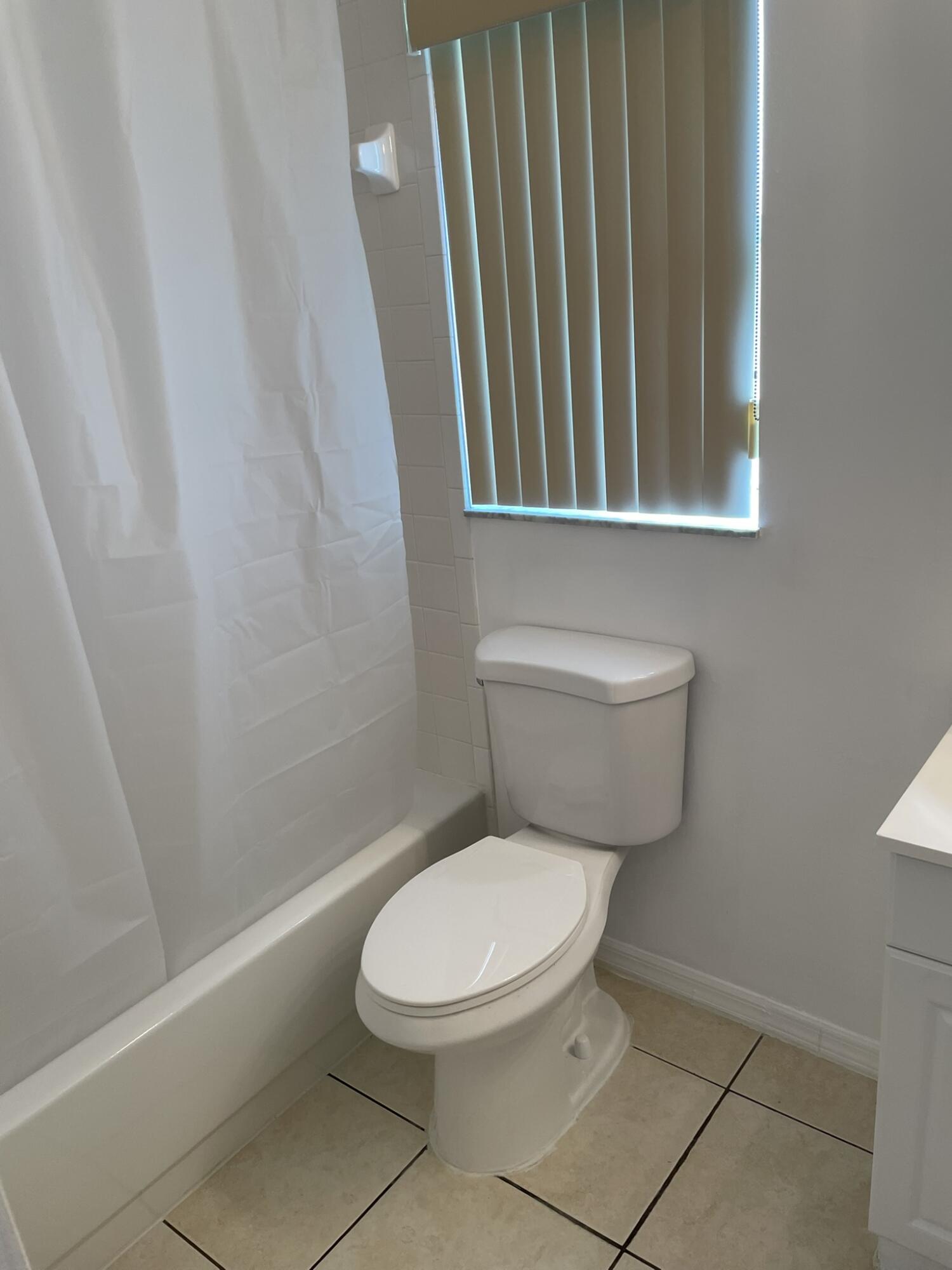 4448 Northwest Bighorn Avenue Port St. Lucie, FL 34983 - Photo 14 of 19 a white toilet sitting next to a bathroom sink