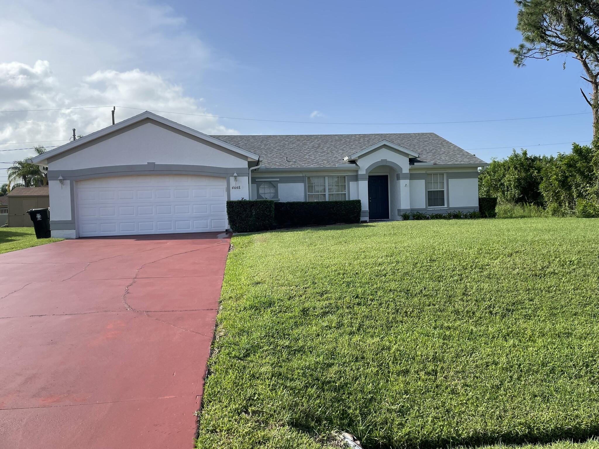 4448 Northwest Bighorn Avenue Port St. Lucie, FL 34983 - Photo 2 of 19 a front view of a house with yard and green space