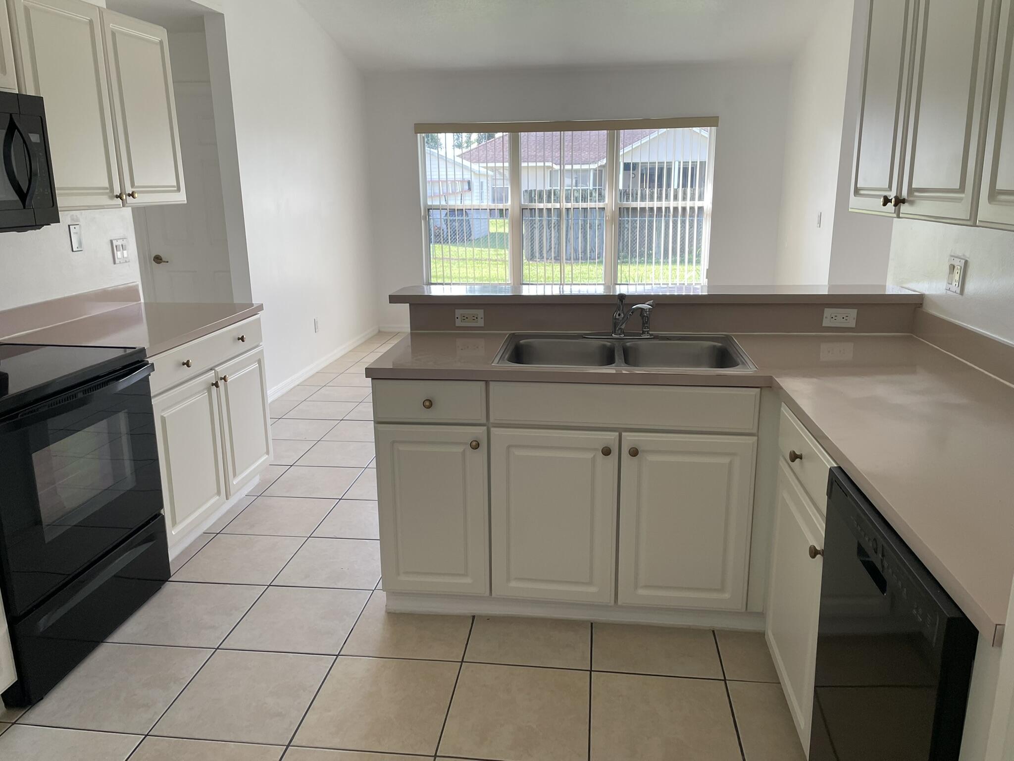 4448 Northwest Bighorn Avenue Port St. Lucie, FL 34983 - Photo 7 of 19 a kitchen with a sink and cabinets