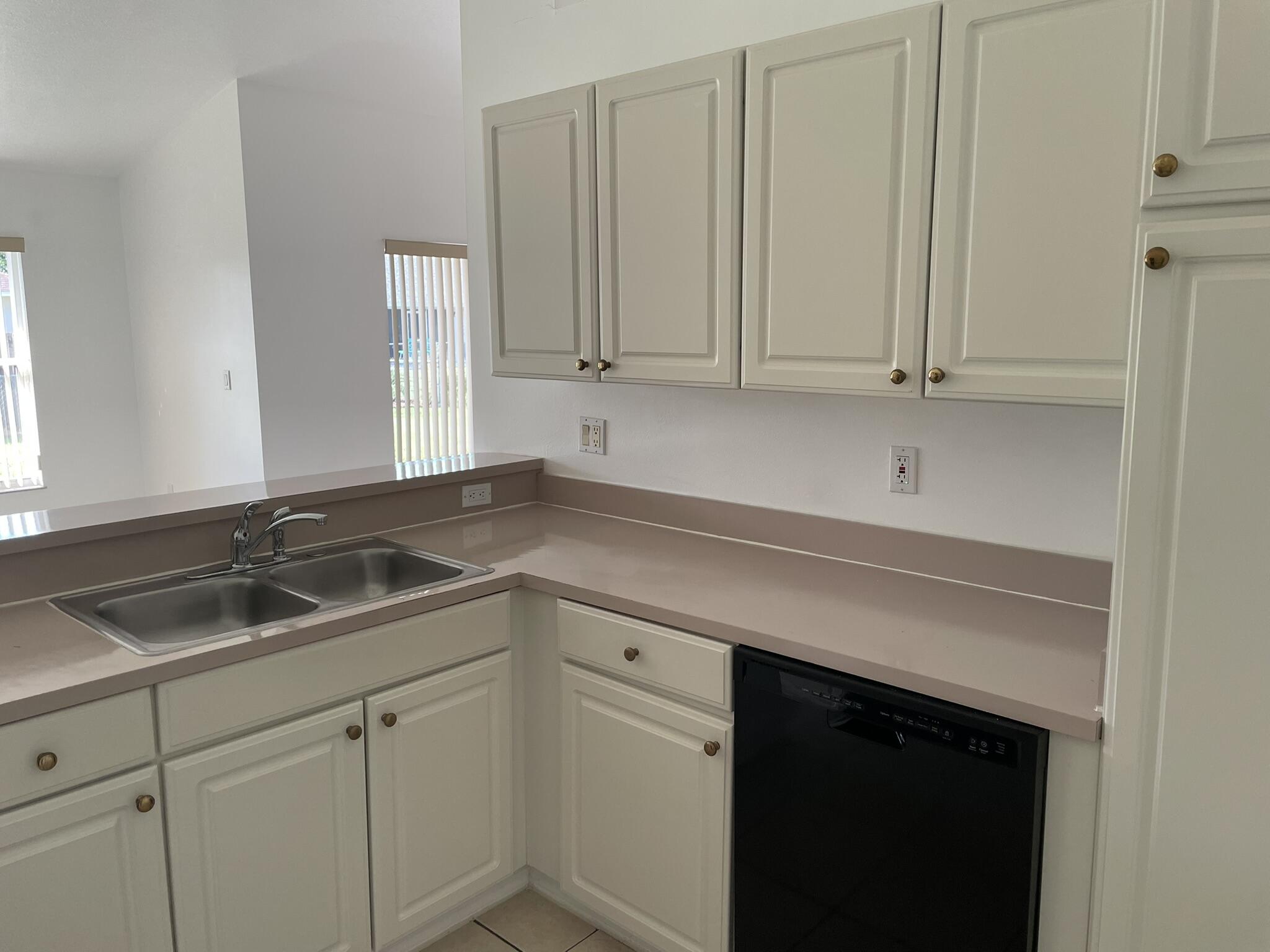 4448 Northwest Bighorn Avenue Port St. Lucie, FL 34983 - Photo 9 of 19 a kitchen with white cabinets and a sink