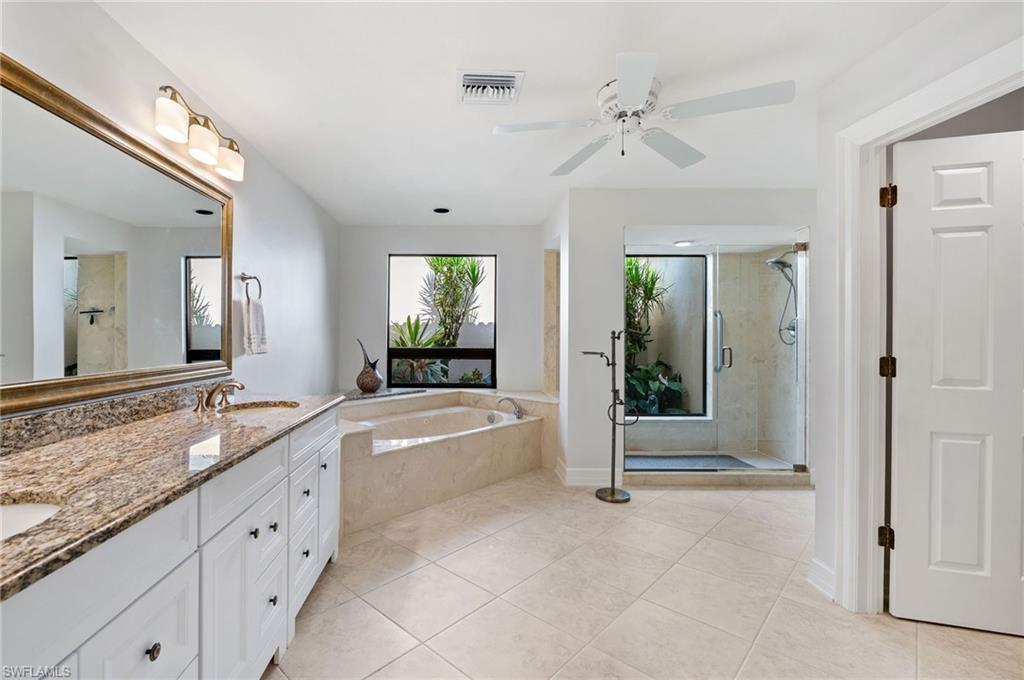 2209 Regal Way Naples, FL 34110 - Photo 14 of 24 a spacious bathroom with a granite countertop tub shower and mirror