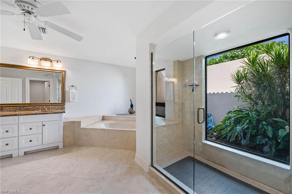2209 Regal Way Naples, FL 34110 - Photo 15 of 24 a bathroom with a granite countertop tub shower and sink