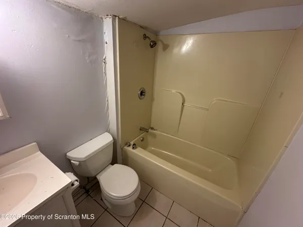 a white toilet sitting next to a bath tub