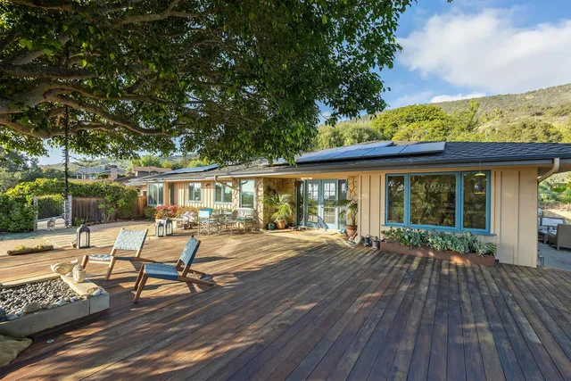 a view of a house with lounge chairs and wooden floor
