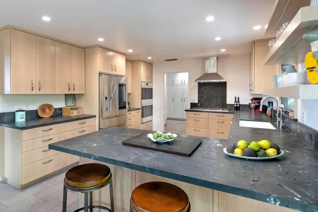 a kitchen with a sink a stove and chairs