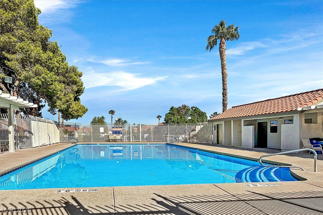 8830 Haviland Road Las Vegas, NV 89123 - Photo 43 of 43 A pristine community swimming pool is framed by safety fencing under a bright blue sky.