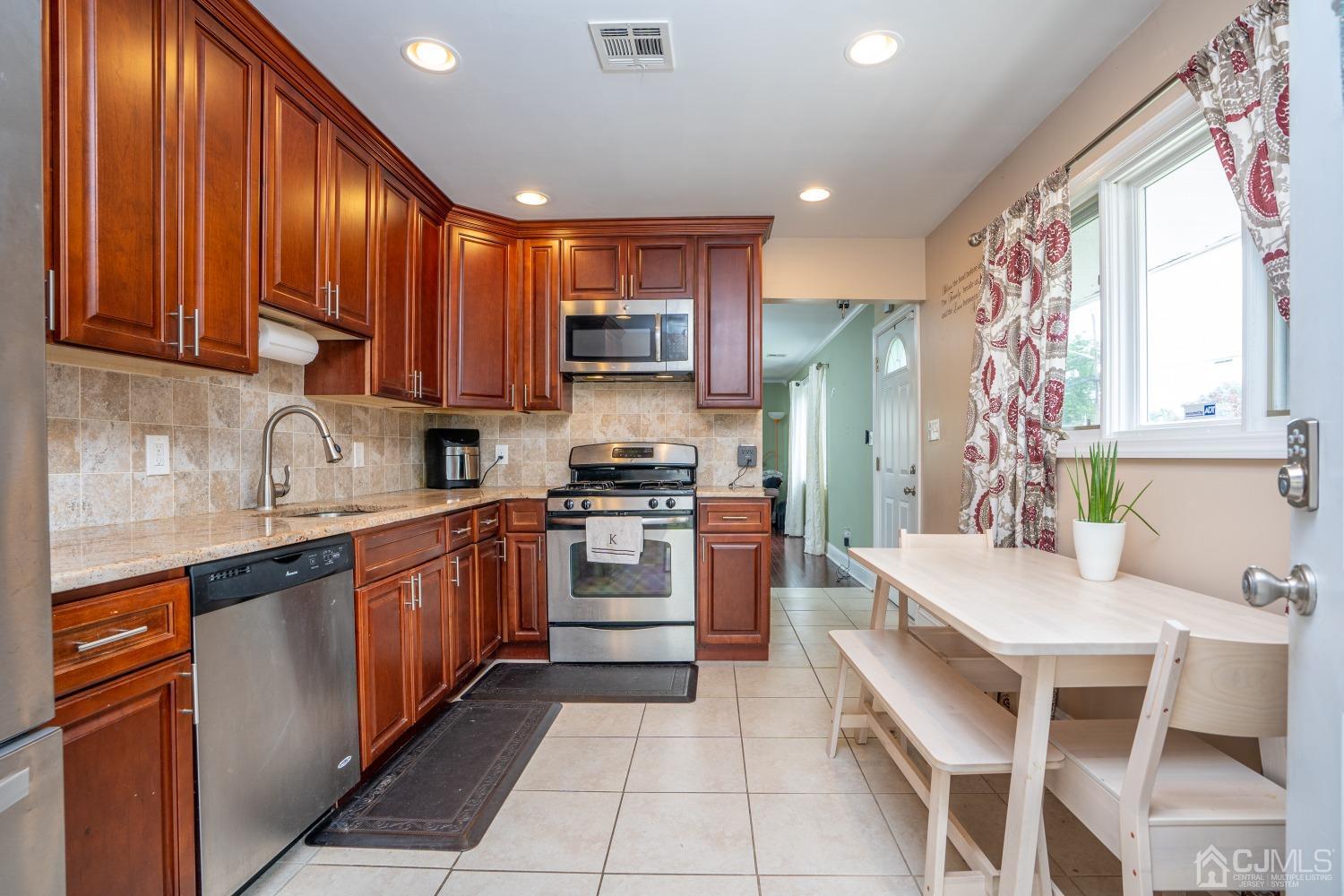 24 Kenmore Road Edison, NJ 08817 - Photo 3 of 21 a large kitchen with stainless steel appliances granite countertop a stove a sink dishwasher and a refrigerator
