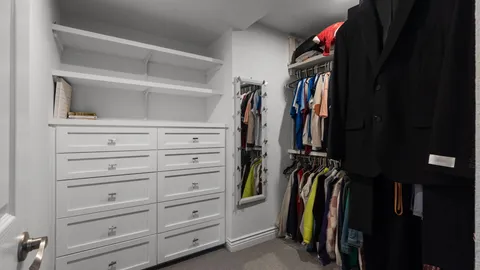 a view of walk in closet with clothes and shoes