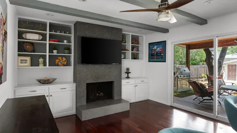 a living room with furniture a flat screen tv and a fireplace