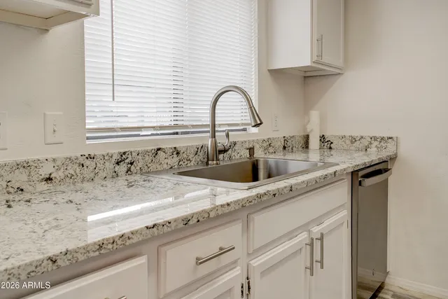 a kitchen with granite countertop white cabinets and white appliances