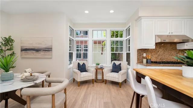 a kitchen with a table chairs microwave and cabinets