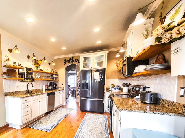 a large kitchen with stainless steel appliances granite countertop a sink and cabinets