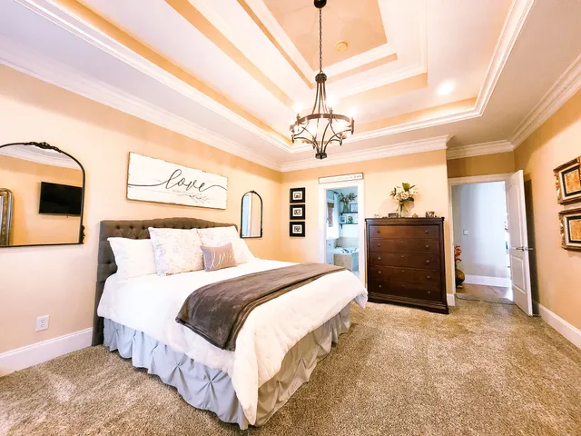 a spacious bedroom with a bed and a chandelier