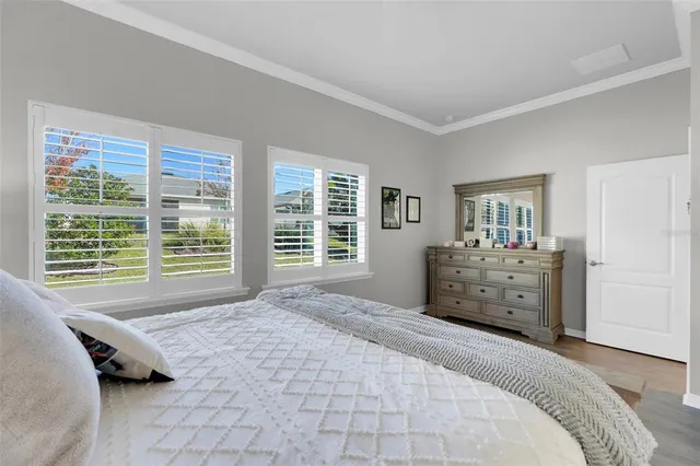 a large bed sitting in a bedroom next to a window and dresser