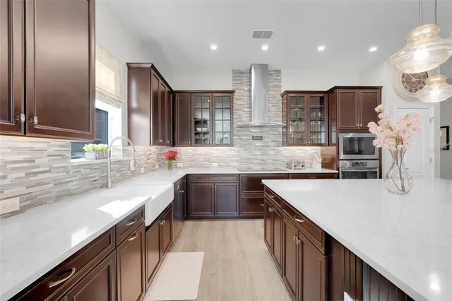 a large kitchen with stainless steel appliances kitchen island granite countertop a large counter top a stove and a sink