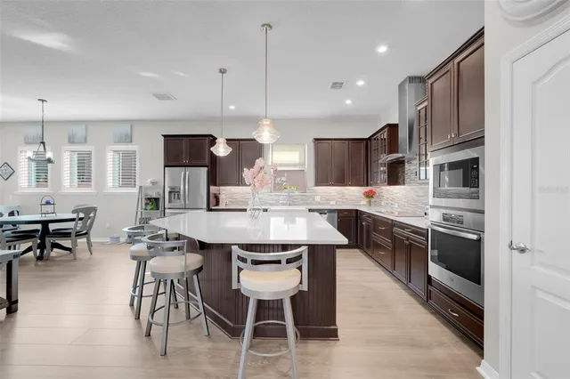 a kitchen with stainless steel appliances kitchen island granite countertop a sink and a refrigerator