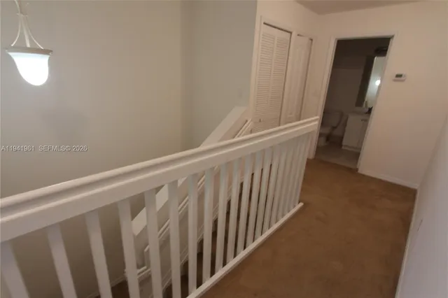 a view of staircase with white walls and a window