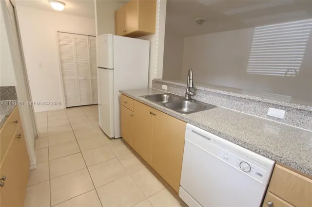 a kitchen with a sink a refrigerator and cabinets