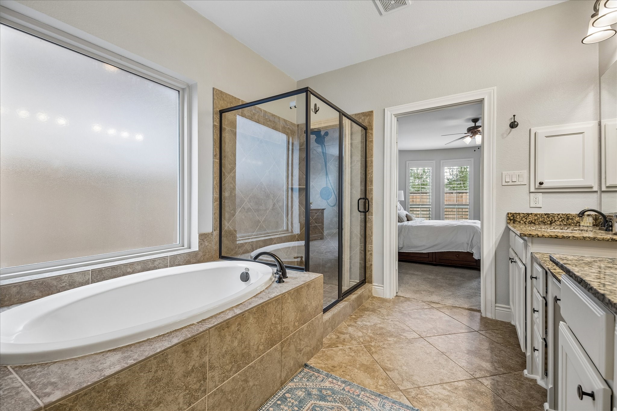 1616 Hewitt Drive Houston, TX 77018 - Photo 15 of 44 Spa inspired primary bath features a soaking tub, walk in shower with glass enclosure, and tile flooring.