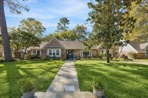 a front view of a house with a yard and trees