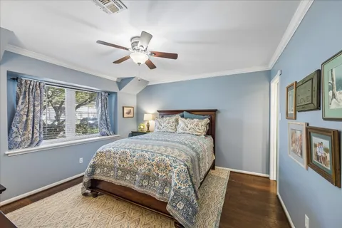 a bedroom with a bed next to a window with a chandelier