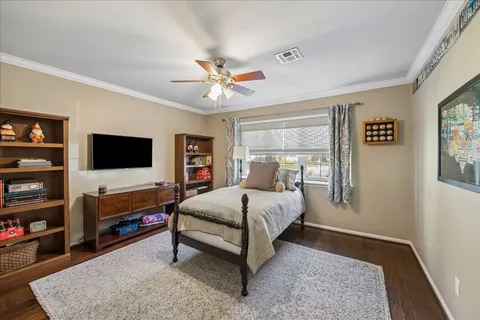 a spacious bedroom with a bed and a flat screen television