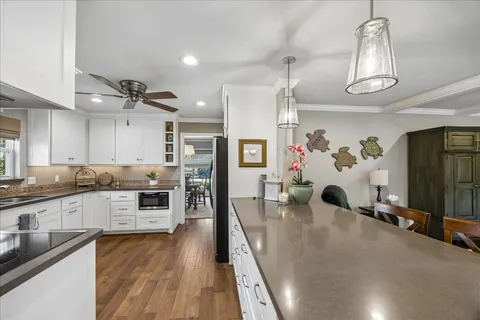 a large kitchen with lots of counter space and wooden floor