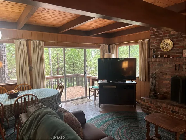 a living room with furniture a flat screen tv and a large window