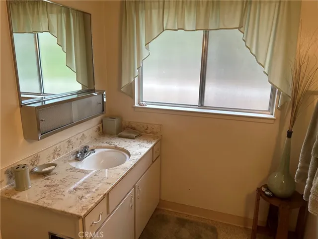 a bathroom with a granite countertop toilet sink and mirror