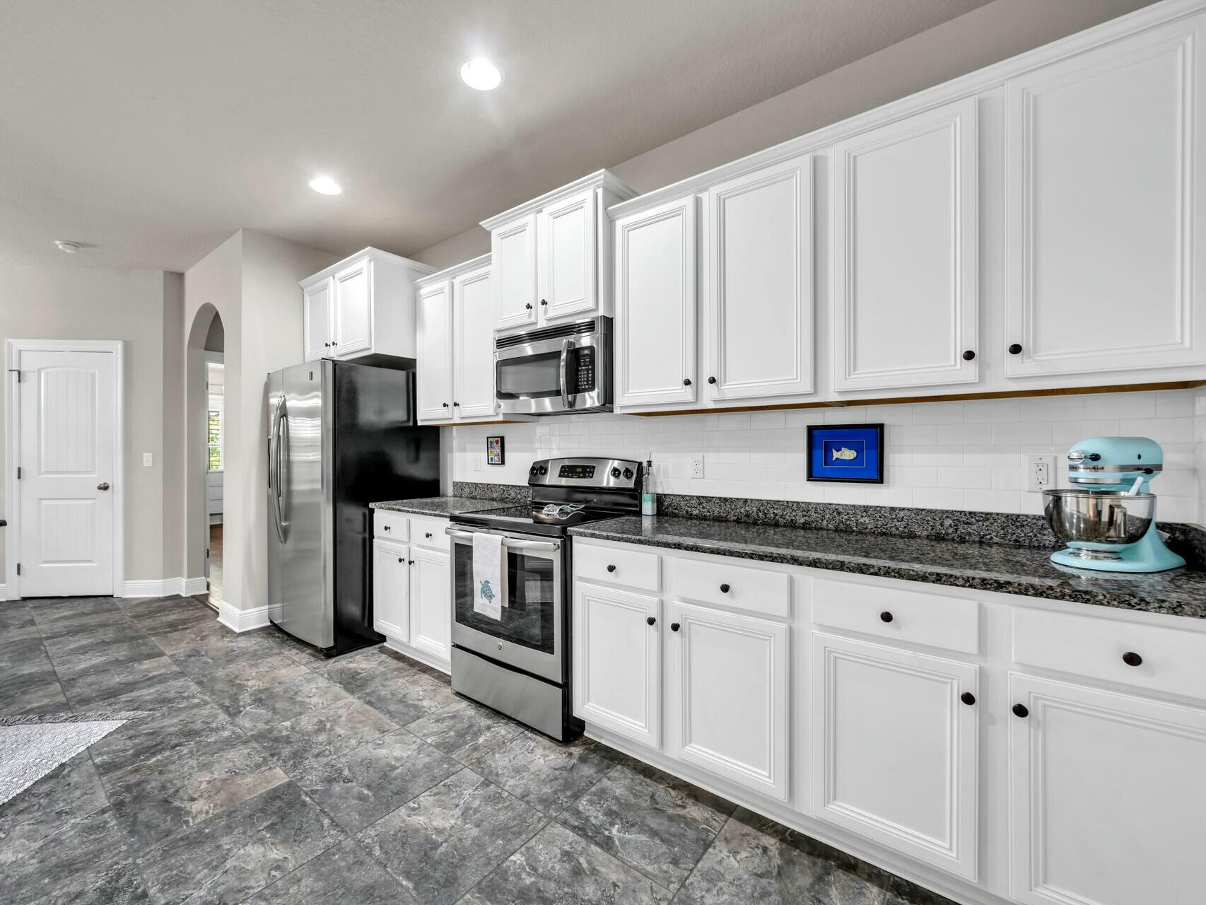 188 Ocean Spray Circle Santa Rosa Beach, FL 32459 - Photo 34 of 75 a kitchen with granite countertop white cabinets and stainless steel appliances