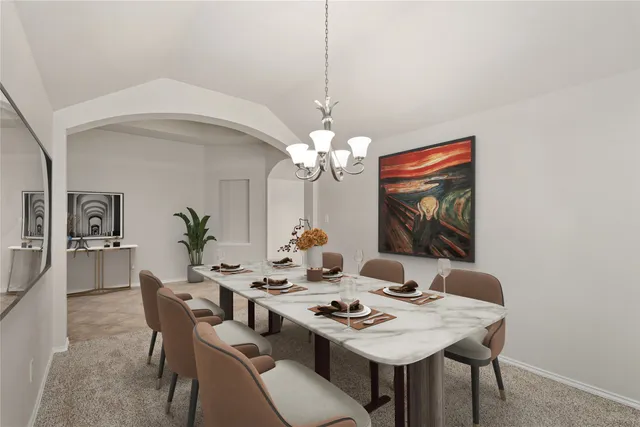a view of a dining room with a table and chairs