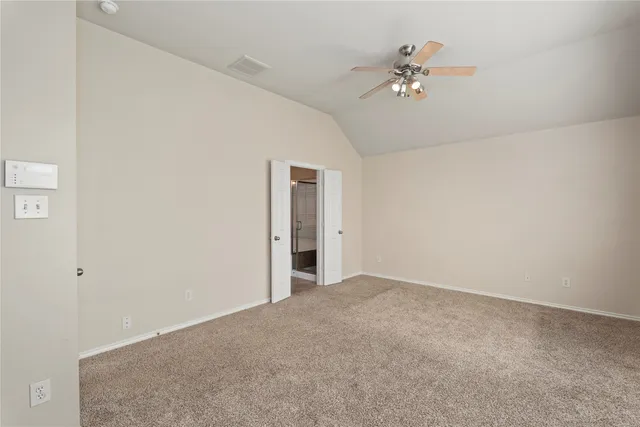 an empty room with a chandelier fan and closet
