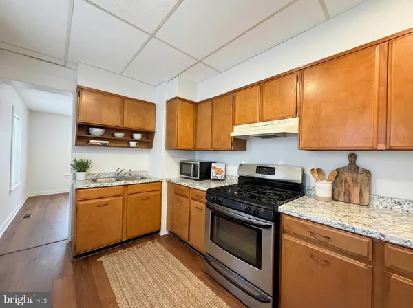 a kitchen with stainless steel appliances granite countertop wooden cabinets stove top oven a sink and dishwasher