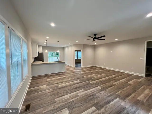 a view of an empty room with window and a chandelier fan