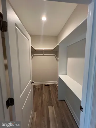 an empty room with wooden floor chandelier fan and windows