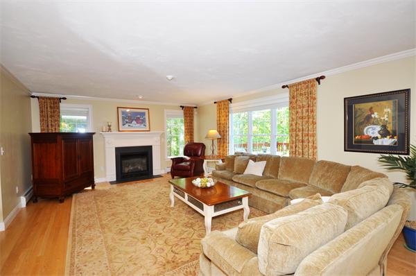 71 Chamberlain Road Westford, MA 01886 - Photo 4 of 30 a living room with furniture a fireplace and a flat screen tv