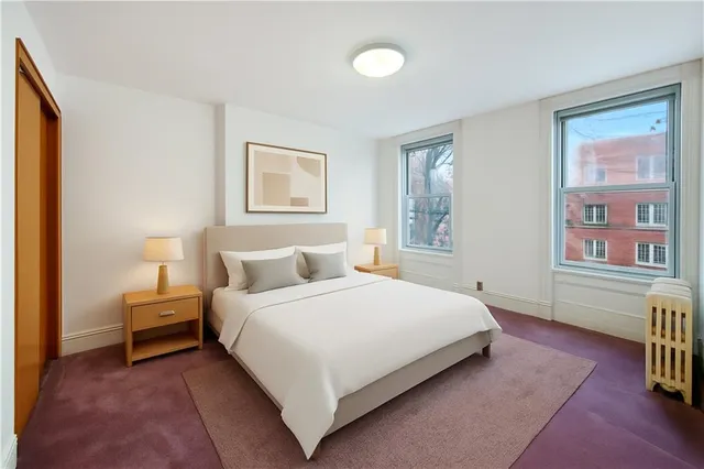 a bedroom with a bed and a painting on the wall