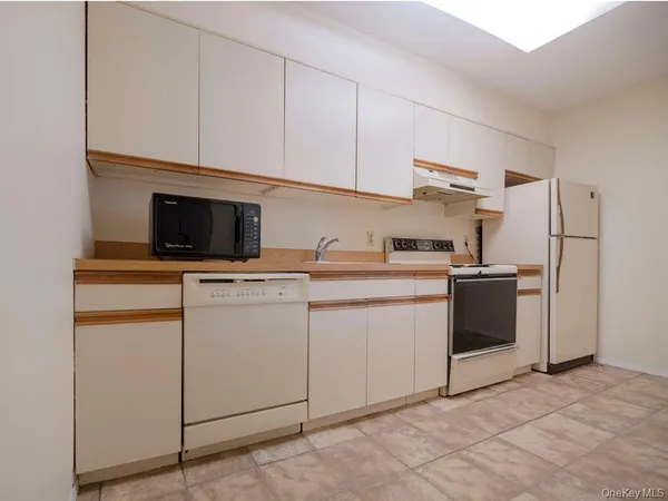 a kitchen with white cabinets and white appliances