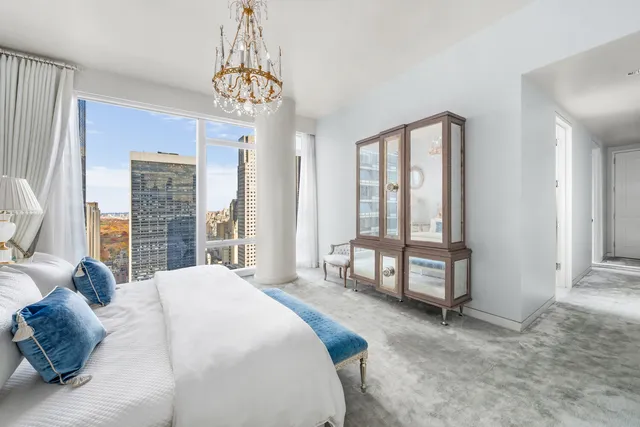 a spacious bedroom with a bed and a large window