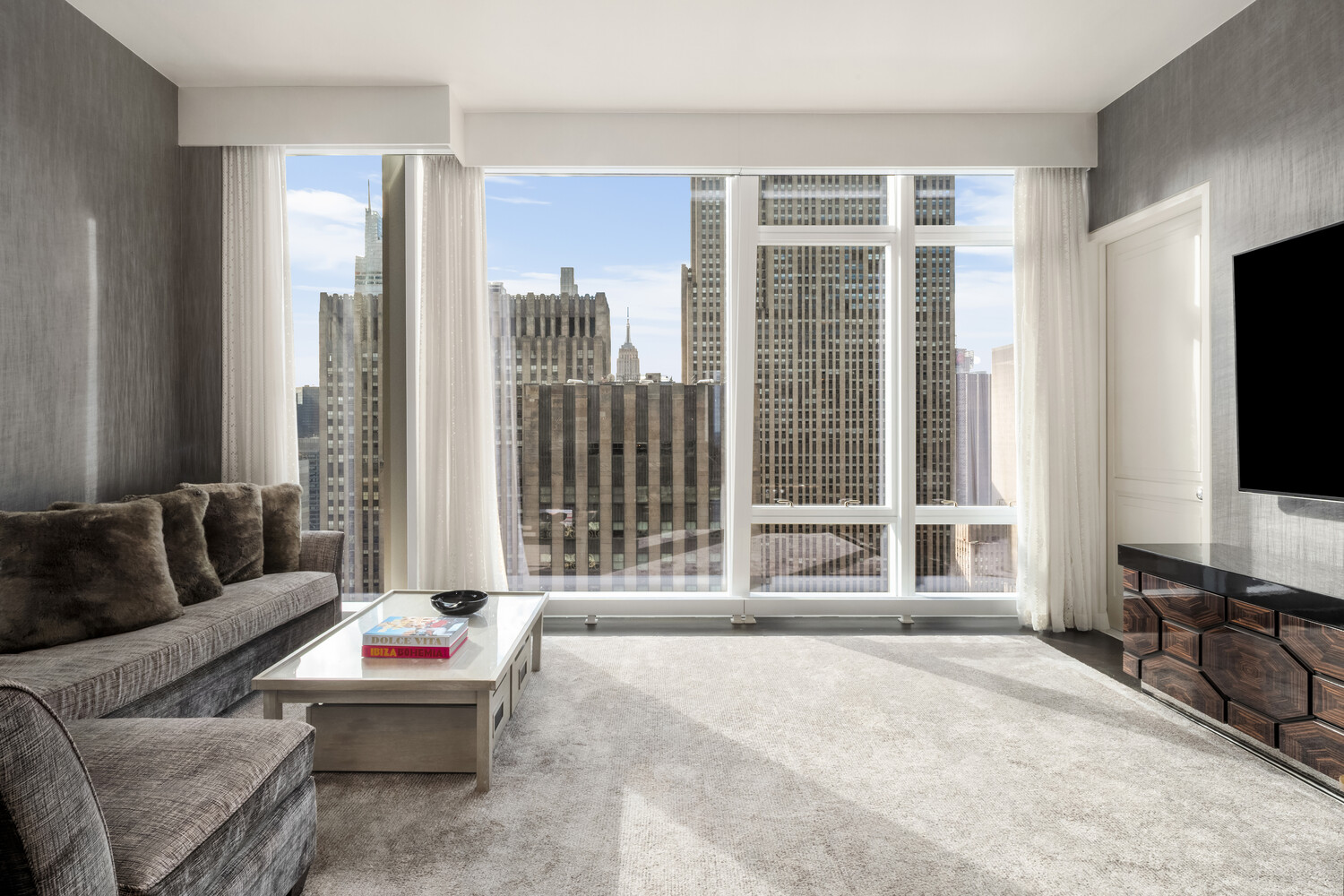 20 West 53rd Street, Unit 38A Manhattan, NY 10019 - Photo 12 of 20 a living room with furniture and a flat screen tv
