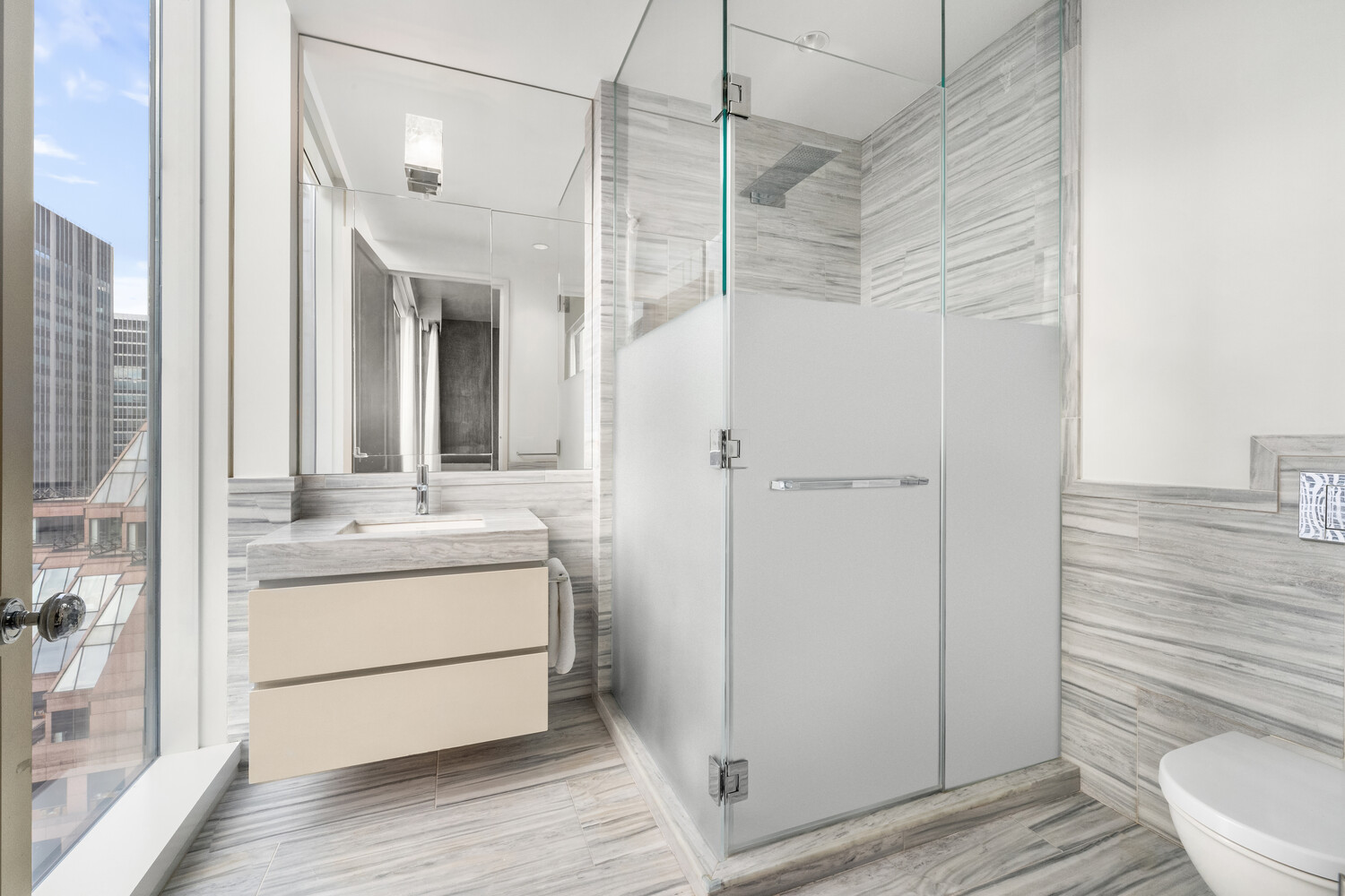 20 West 53rd Street, Unit 38A Manhattan, NY 10019 - Photo 13 of 20 a bathroom with a granite countertop sink toilet and shower