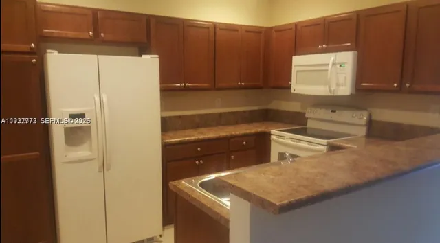 a kitchen with a refrigerator a sink and cabinets