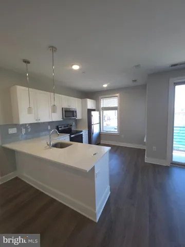 a large kitchen with cabinets wooden floor and a window