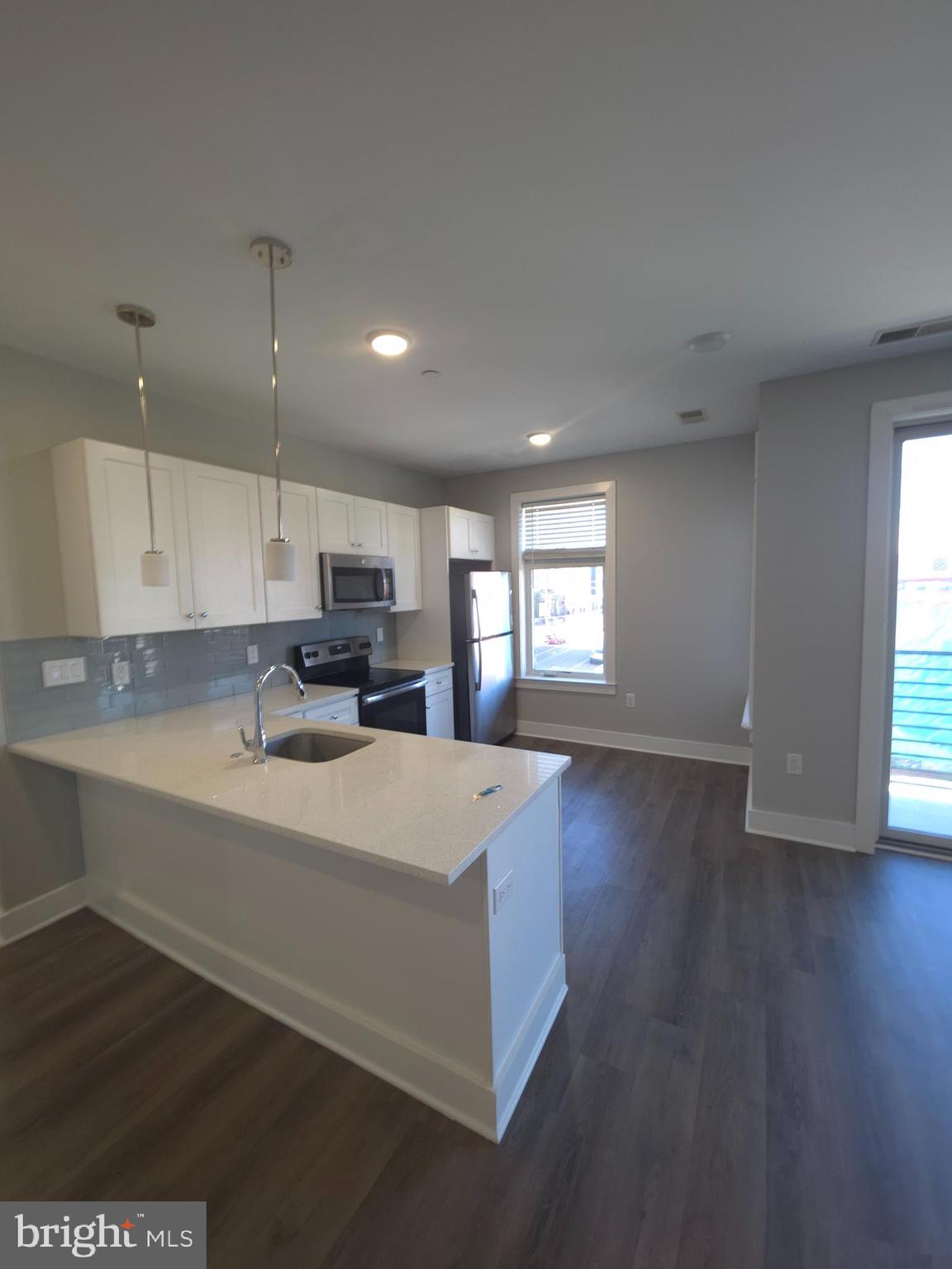 3925 Haverford Avenue, Unit 307 Philadelphia, PA 19104 - Photo 21 of 37 a large kitchen with cabinets wooden floor and a window