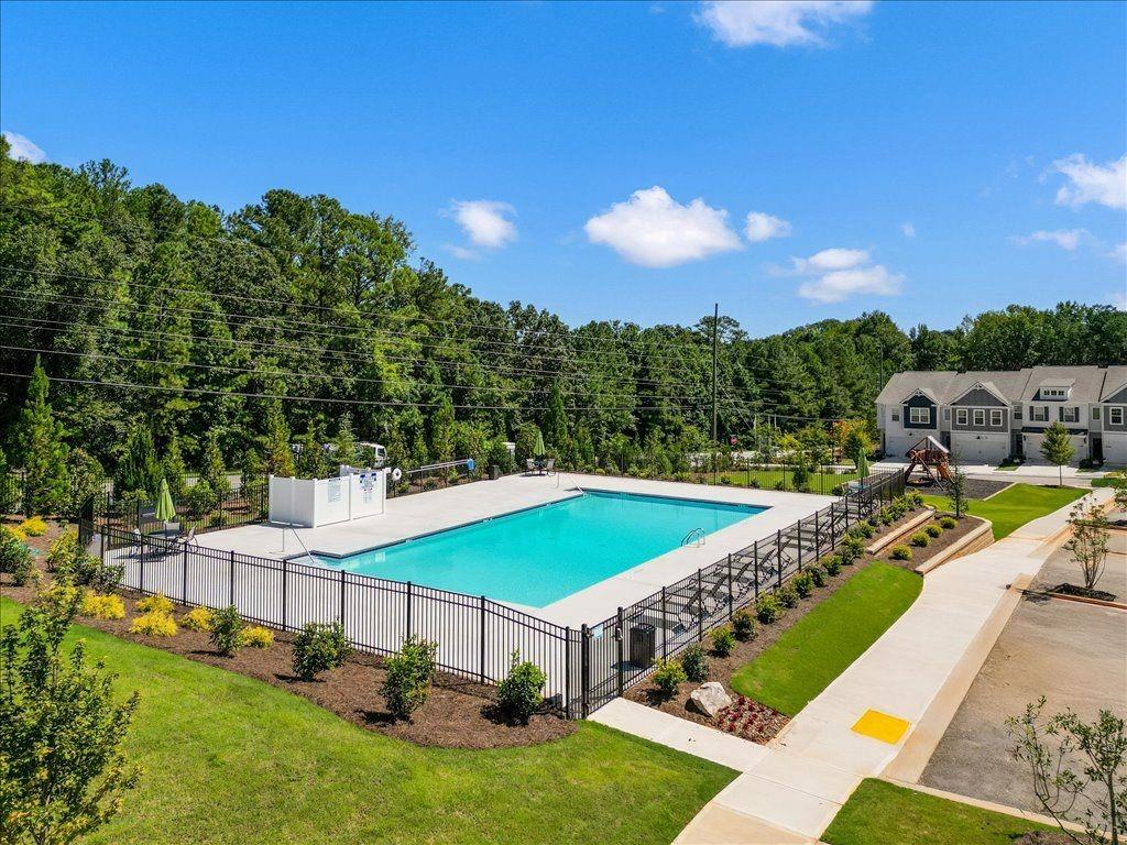 2526 Riverside Court Northeast Conyers, GA 30013 - Photo 20 of 22 a view of a swimming pool with lawn chairs under an umbrella