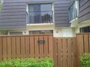 a view of a house with a wooden fence