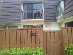 a view of a house with a wooden fence