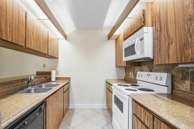 a kitchen with a stove a refrigerator and a sink