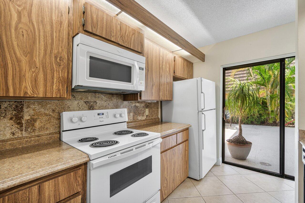 1619 16th Court Jupiter, FL 33477 - Photo 17 of 31 a kitchen with a stove a refrigerator and a sink